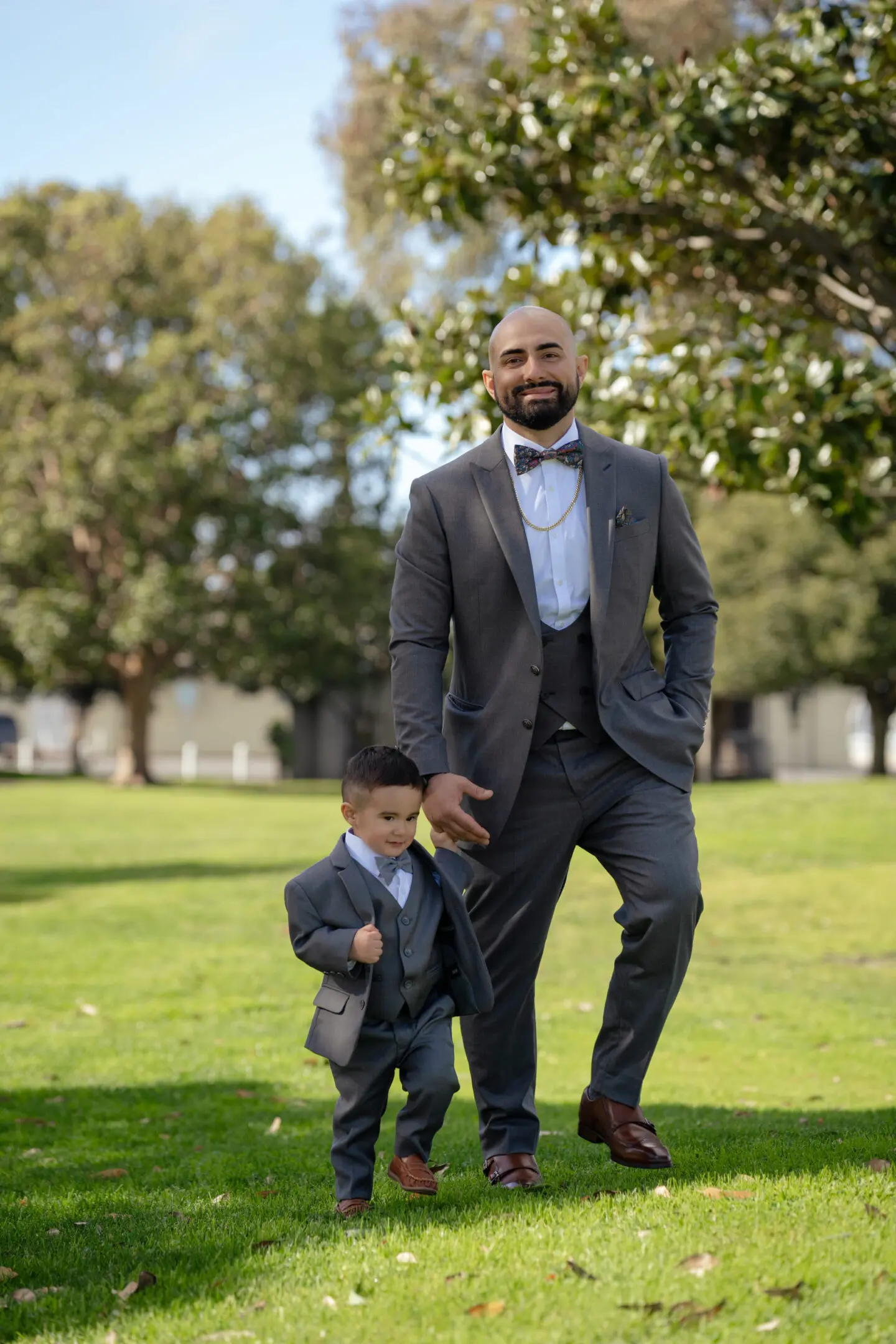 Man and young boy in suits outdoors