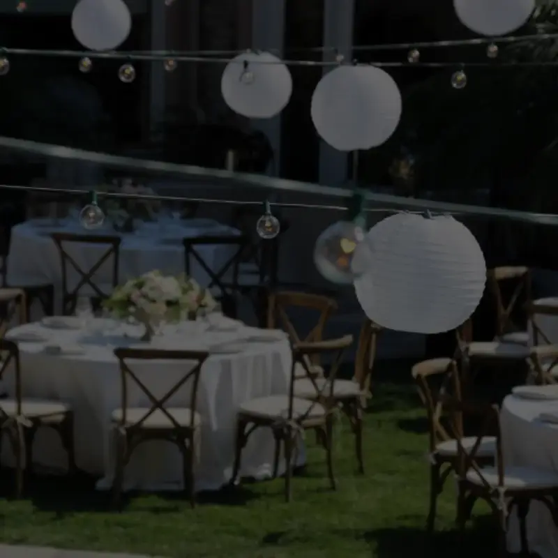 Outdoor wedding reception tables with paper lanterns