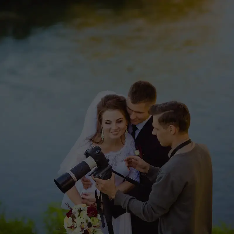 Bride and groom reviewing photos with photographer
