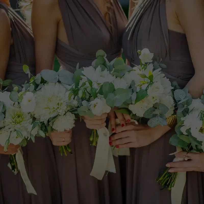 Bridesmaids holding white bouquets with eucalyptus