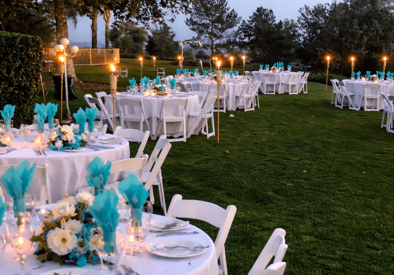 Outdoor wedding reception tables with turquoise accents