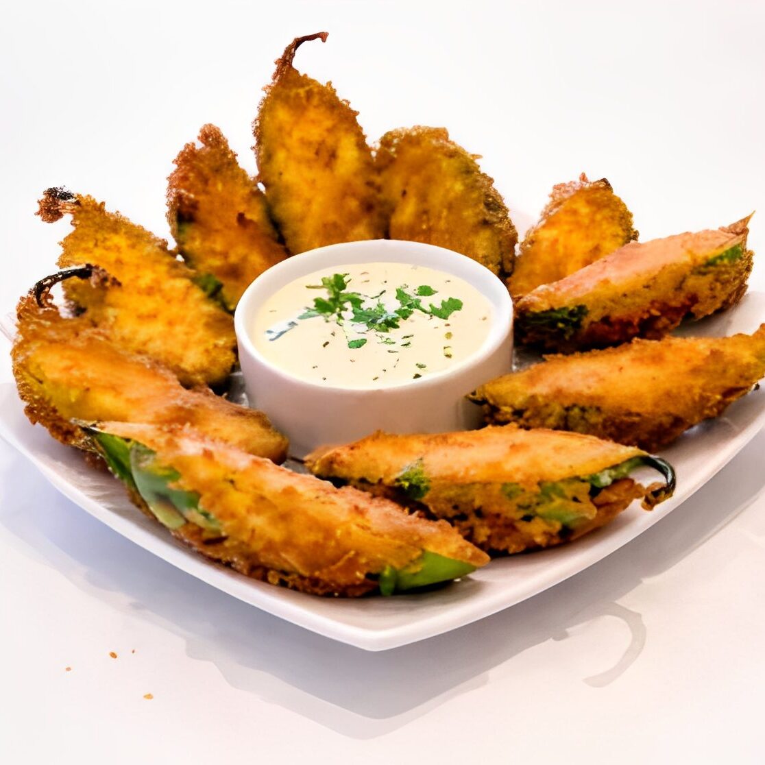 Plate of jalapeno poppers with dipping sauce